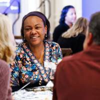 An alum smiles while speaking with two fellow Lakers